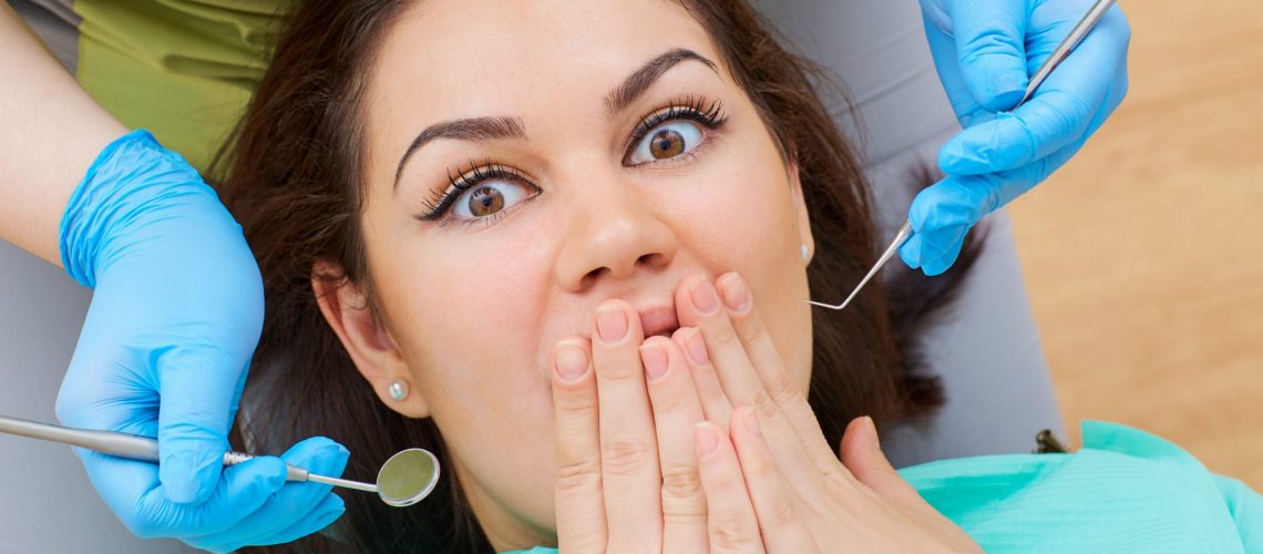 Concept phobia dentist, dental office. Young girl at the dentist